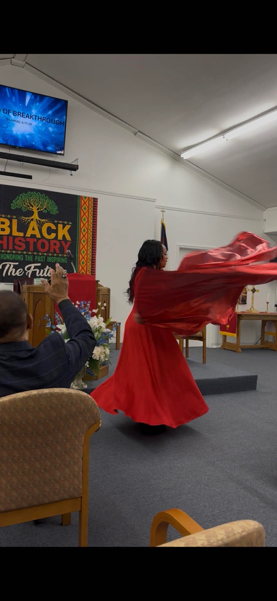 Starr in flowing red garment — worship dance during a Black History service